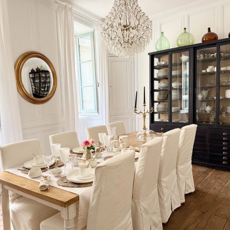 Salle à manger du Clos Notre Dame, chambres d’hôtes à Poitiers centre, avec table en bois, chaises blanches, lustre et vaisselier.