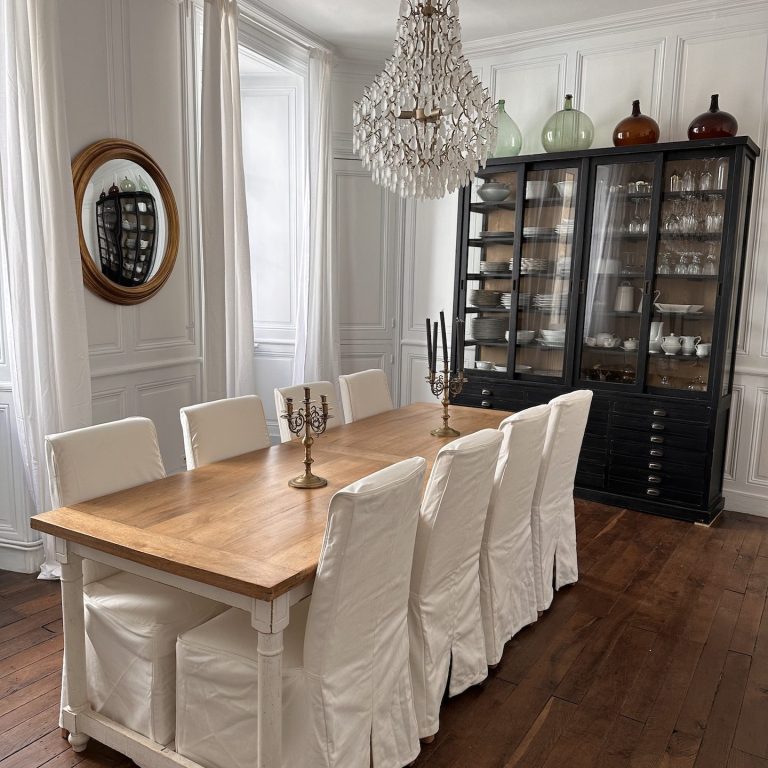 Salle à manger du Clos Notre Dame, chambres d’hôtes à Poitiers centre, avec table en bois, chaises blanches, lustre et vaisselier.